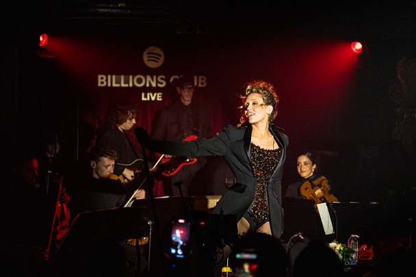 Miley Cyrus di atas panggung dengan band di belakangnya