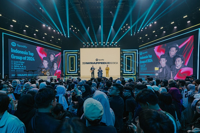 Para musisi tampil di atas panggung dalam acara Spotify Wrapped, dengan penonton terlihat di gambar