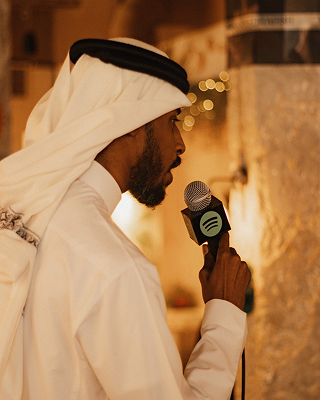 DJ Mubarak speaking with a mic in hand