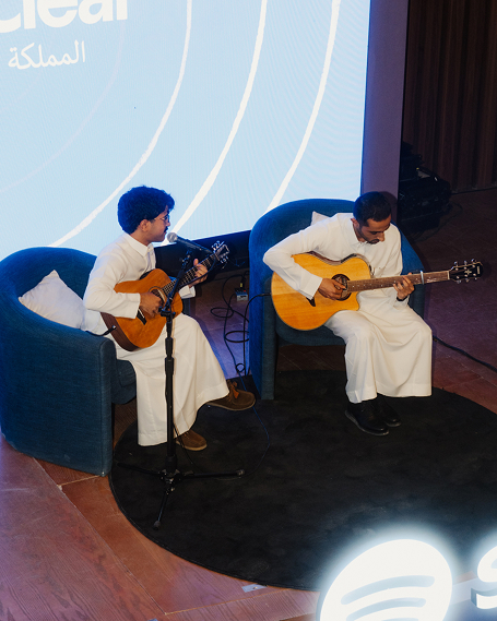 Yazeed Fahad seated and playing guitars